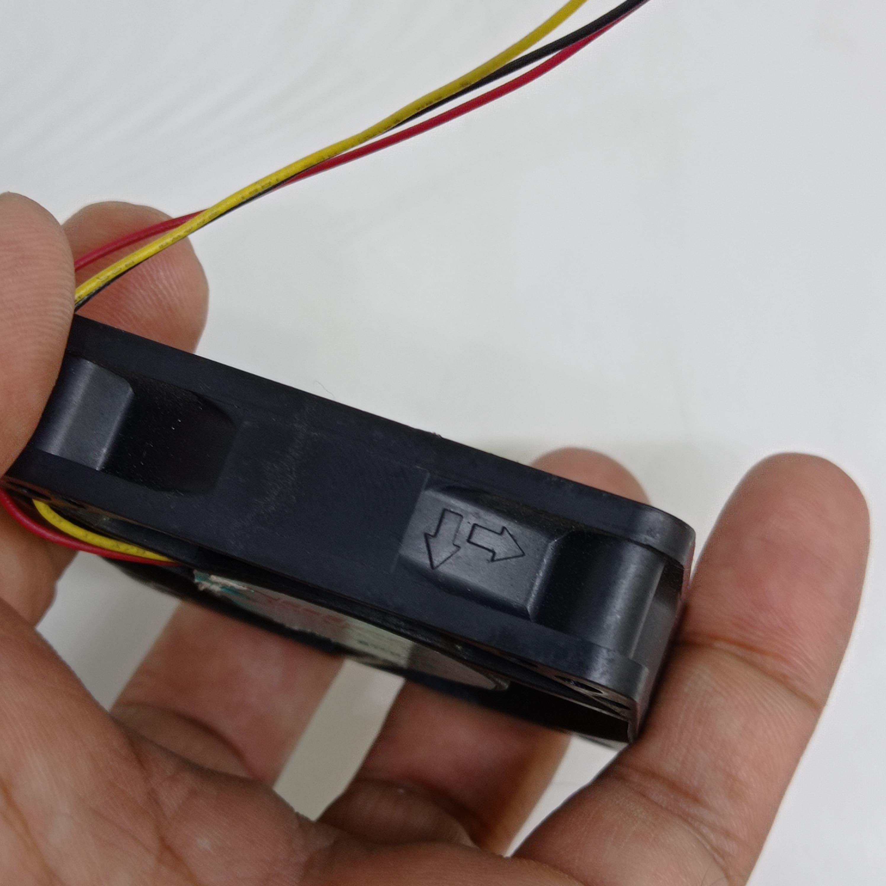 NEW 24V 60mm x 60mm x 15mm Brushless DC Cooling Fan - a close-up of the black fan housing showing the airflow direction arrows molded into the side.