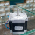 New NEMA 23 Stepper Motor JK57HS56-2804-01 - a silver and black square motor with a central metal shaft and four colored wires extending from the side.