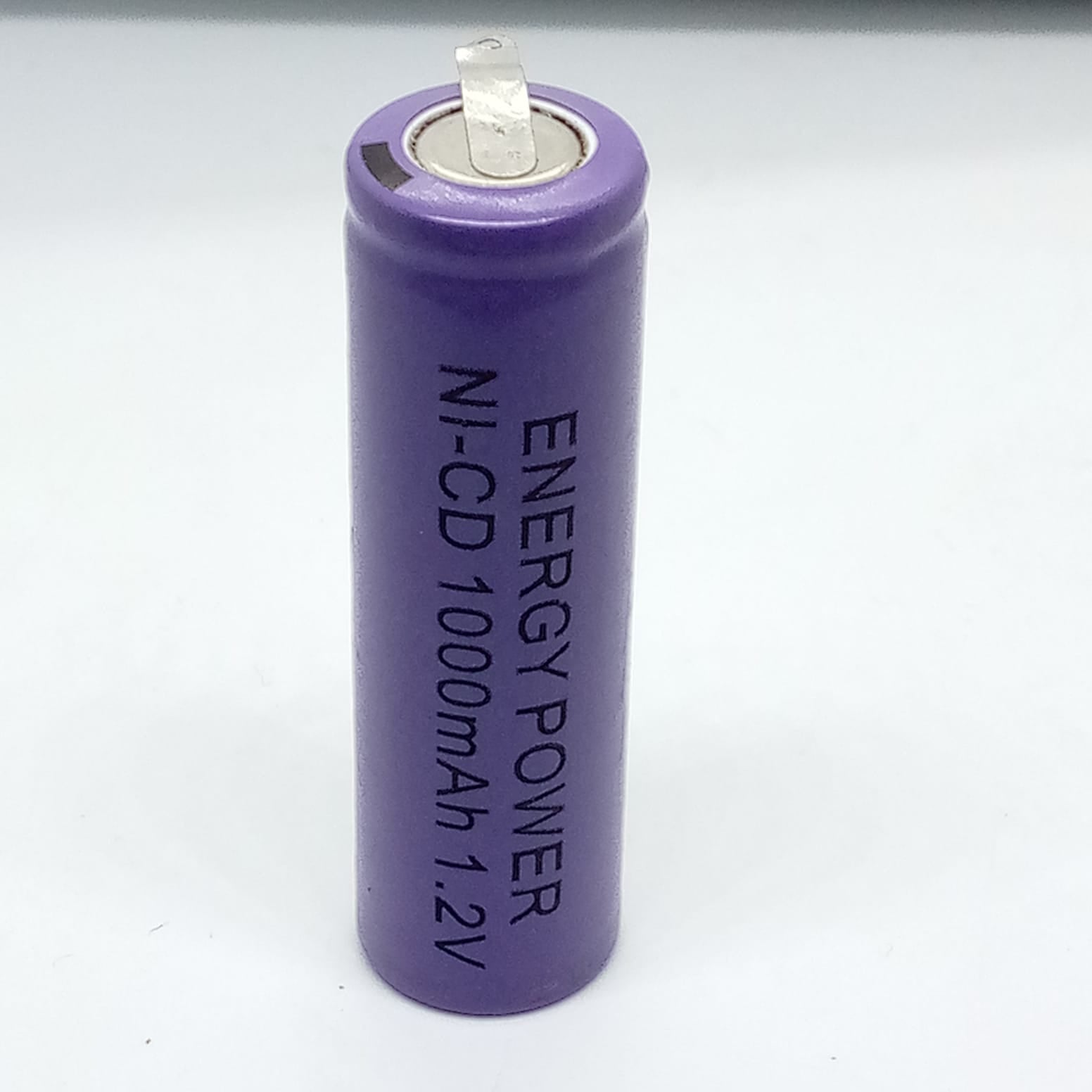Ni-Cd AA Cell Rechargeable Battery 1000mAh 1.2V - a purple cylindrical battery with a metal contact terminal on top and printed text on its side.