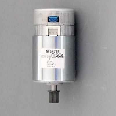 Nisca Servo DC Motor With Encoder NF5475E DC 24V To 38V And 3500 To 5000RPM - a cylindrical silver motor with a black gear on the shaft, a top connector port, and a label showing model specifications.