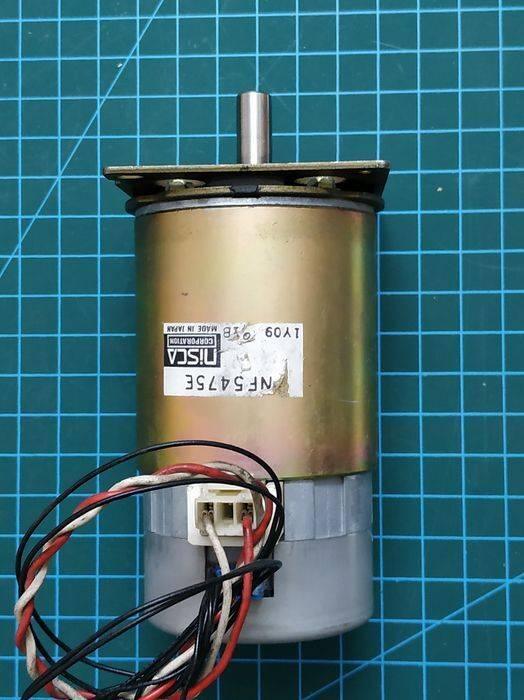 Nisca Servo DC Motor With Encoder NF5475E DC 24V To 38V And 3500 To 5000RPM - a cylindrical gold-colored motor with a metal shaft, a white connector port, and attached black, white, and red wires.