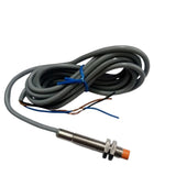 NPN Proximity Sensor - shown as a cylindrical metal threaded sensor with an orange tip, connected to a long grey cable with three exposed wire ends.