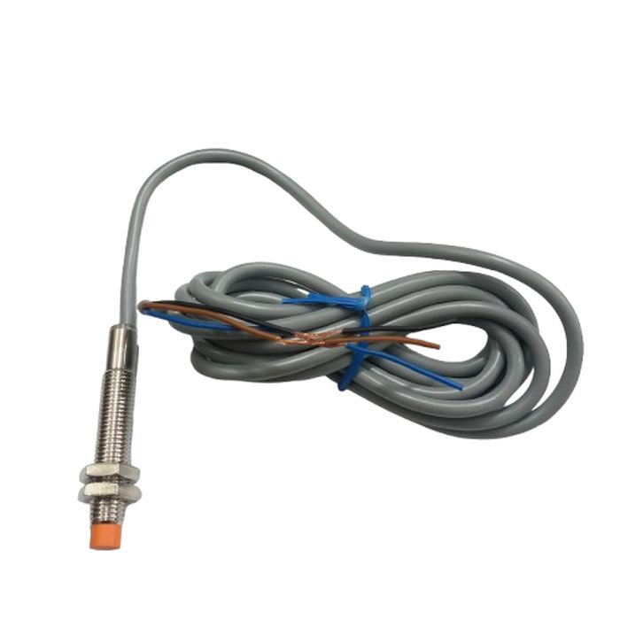 NPN Proximity Sensor - a threaded metal cylindrical body with an orange tip and an attached gray cable with exposed brown, blue, and black wires.