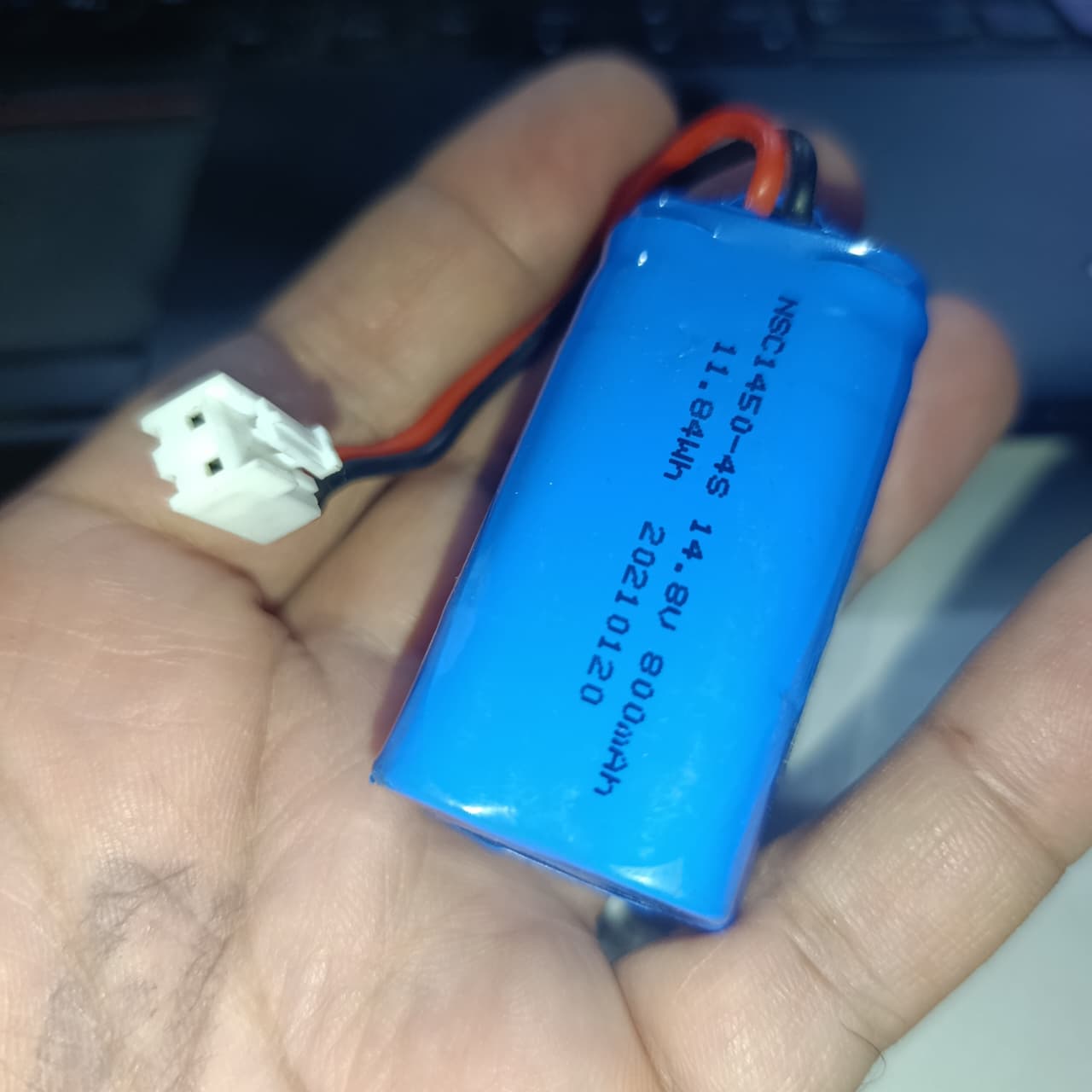 NSC145-4S 14.8V 800mAh Lithium Battery 5mm Pitch Connector (4S Li-ion Rechargeable With BMS) - a blue cylindrical battery pack with a white 2-pin connector, held in a hand.