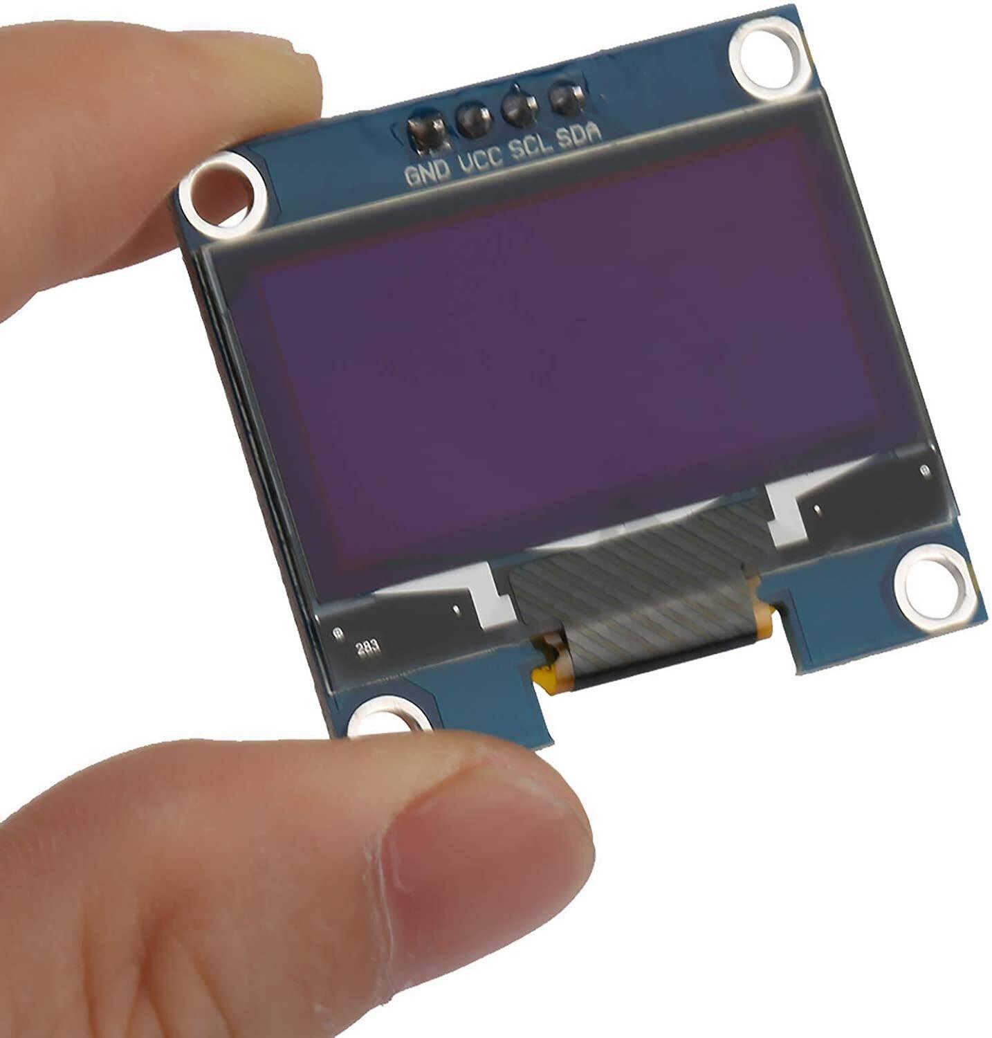OLED 1.3 Inch Display Module 128x64 I2C Communicate 4pin SSD1106 Blue Text Color - held by a hand, showing its blue screen, four connection pins labeled GND, VCC, SCL, and SDA.