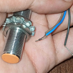 Omron Inductive Proximity Sensor Switch E2e-X2E1 - shown as a close-up of the threaded metal cylinder with an orange tip and three exposed wire leads.