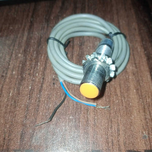 Omron Inductive Proximity Sensor Switch E2e-X2E1 - a cylindrical metal sensor with an orange tip, two mounting nuts, and a grey three-wire cable.
