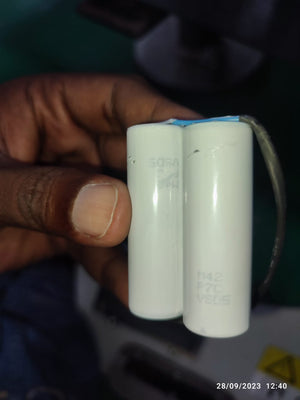 On Demand 7.4V Li Ion Battery For 3HAC044075 Replacement - a close-up of two white cylindrical battery cells connected by a blue strip and wires.