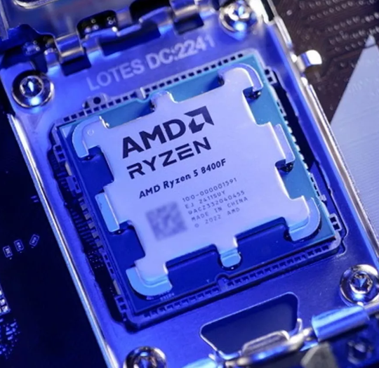 On Demand AMD Ryzen R5 8400F Processor 6 cores and 12 threads - installed in a motherboard socket, featuring a silver heat spreader with printed text and a unique notched metal frame.