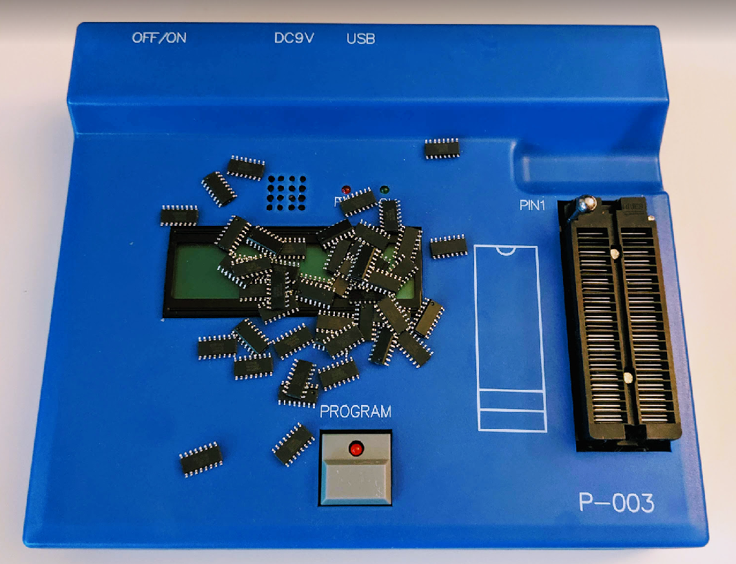 On Demand Cheapest Microcontroller - a blue device with a ZIF socket, a blank LCD screen, a program button, and several loose IC chips on its surface.