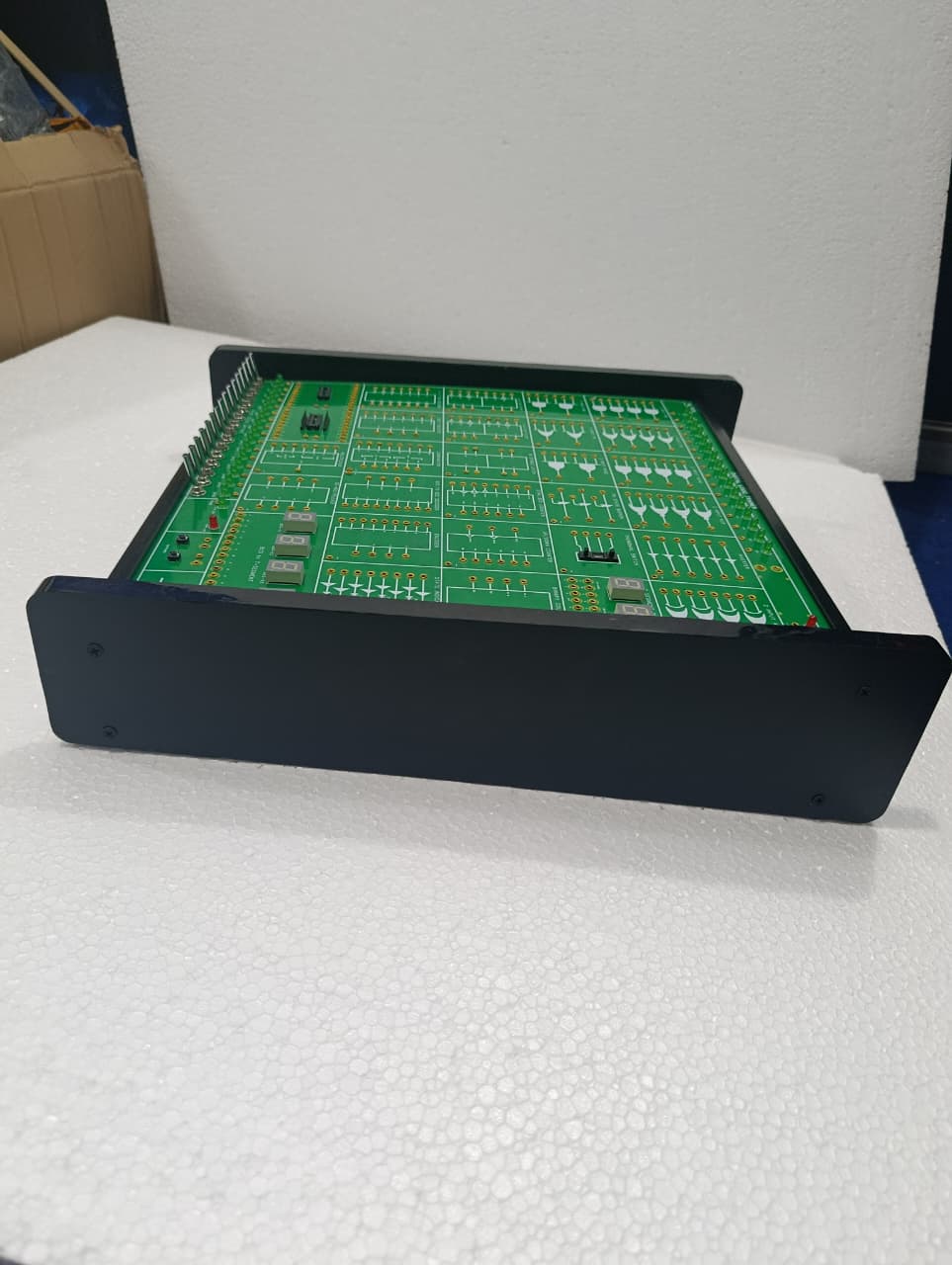On Demand DLD Trainer Digital Logic Trainer WWW.DIGILOG.PK - a green rectangular circuit board with multiple integrated circuit sockets and ports in a black frame.