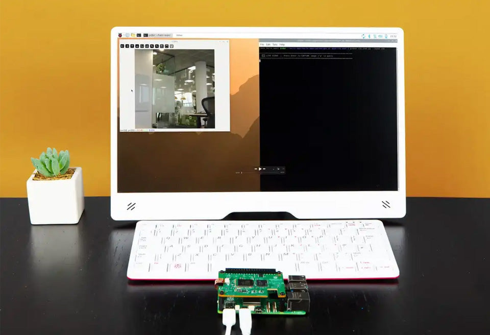 On-demand Official Raspberry Pi AI HAT+ 2, Built-in Hailo-10H AI Accelerator And 8GB Onboard RAM, Comes With Heatsink - connected to a Raspberry Pi board, white keyboard, and monitor showing a camera feed and terminal window on a black desk.