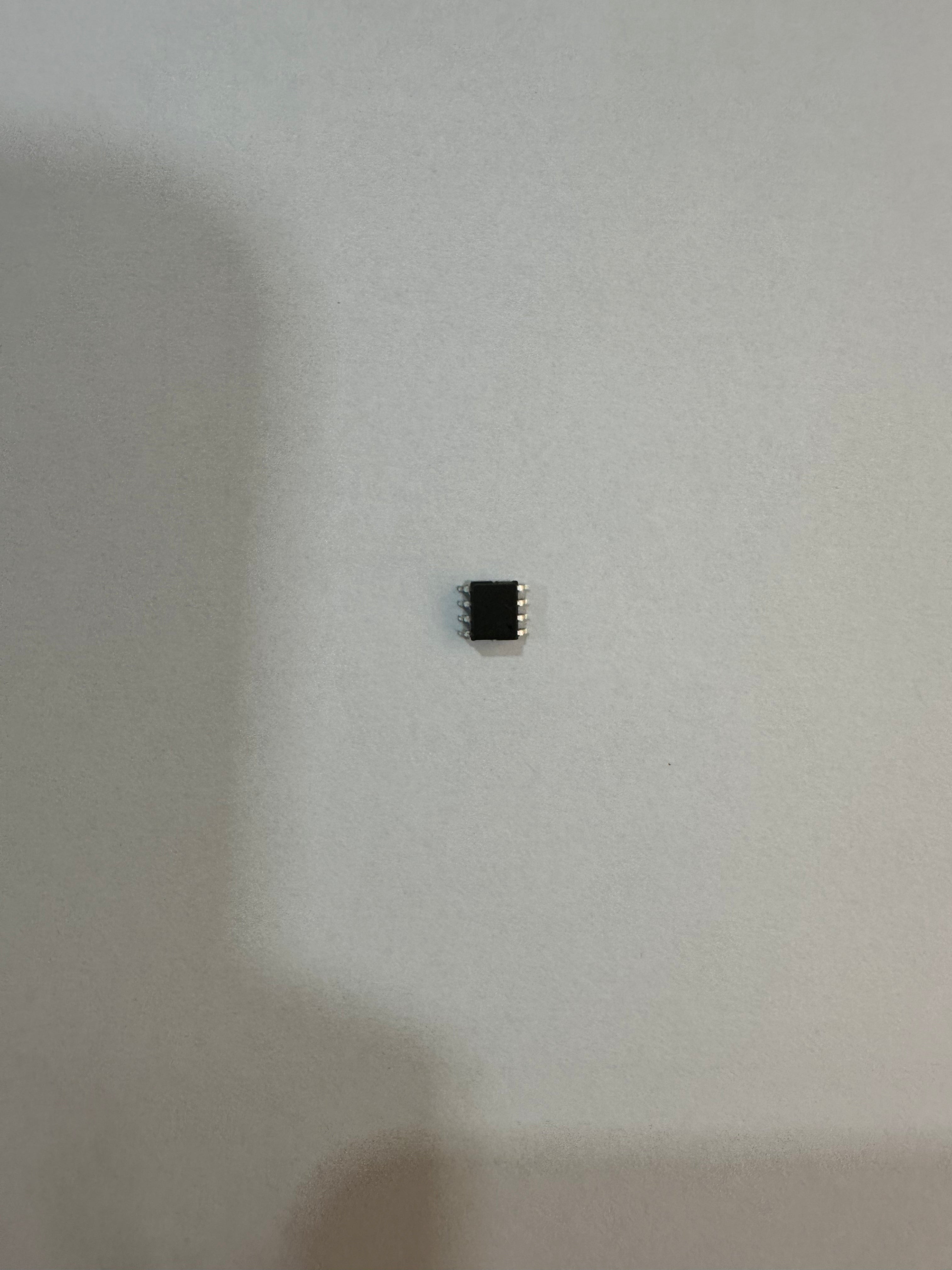 On Demand Programmed 8 Pin SMD IC For Flasher - a small black integrated circuit with four metal pins on each side, shown against a plain background.