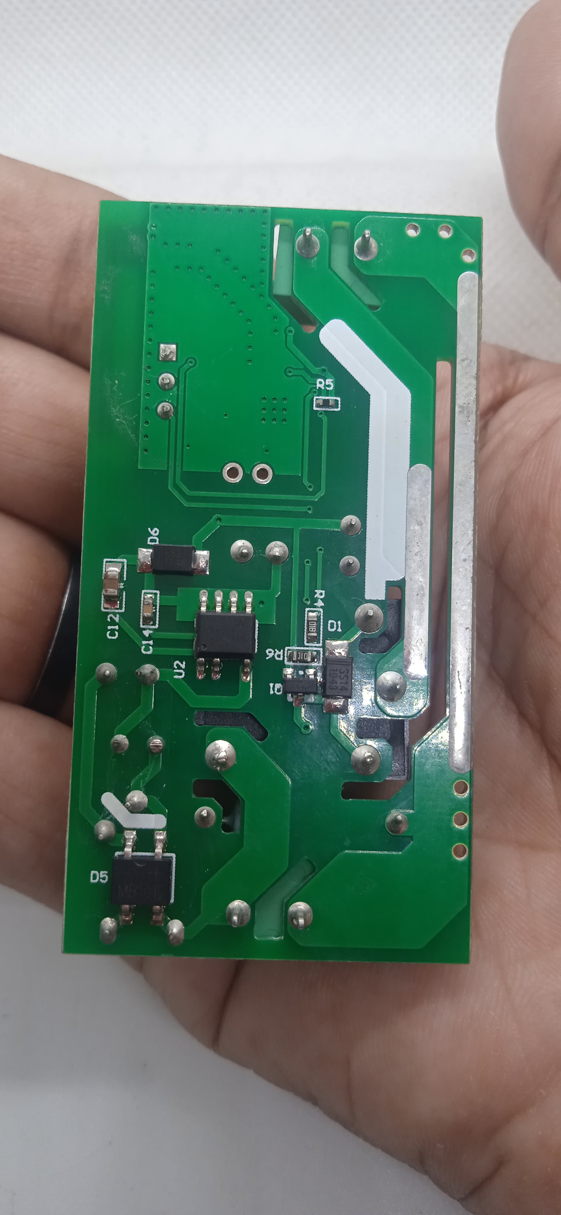 On-Off WiFi remote Switch home automation Module - shown as a green rectangular printed circuit board held in a hand, featuring various electronic components.