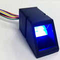 Optical Fingerprint Reader Sensor Module JM-101B 1816C - Buy At Digilog.pk - a black rectangular device with a glowing blue scanner window and a multi-coloured wire harness.