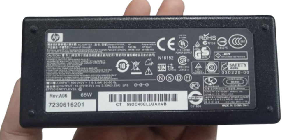Original HP 19.5V 3.33A 65W AC adapter with power cable - a black rectangular power brick showing a detailed technical specification label with HP branding and regulatory icons.