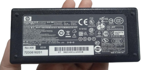 Original HP 19.5V 3.33A 65W AC adapter with power cable - a black rectangular power brick showing a detailed technical specification label with HP branding and regulatory icons.
