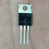Original IRF540N - IRF540 N-channel MOSFET Transistor TO220 Package - a black three-pin electronic component in a TO-220 package with metal tab, held against a skin-toned background.