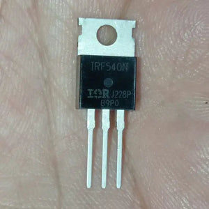 Original IRF540N - IRF540 N-channel MOSFET Transistor TO220 Package - a black three-pin electronic component in a TO-220 package with metal tab, held against a skin-toned background.