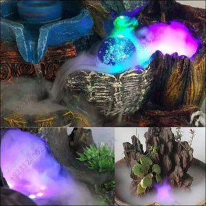 Original Ultrasonic Mist Maker Fogger 12 LED Colorful Light 24V 1A Humidifier with adapter - lights shown creating colorful fog effects in decorative indoor water fountain and plant arrangements.