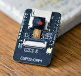 OV3660 ESP32-CAM WiFi + Bluetooth Camera Module Development Board ESP32 With Camera Module OV2640 For Arduino - a black rectangular development board with a central camera lens, a white ribbon cable connector, and an LED.