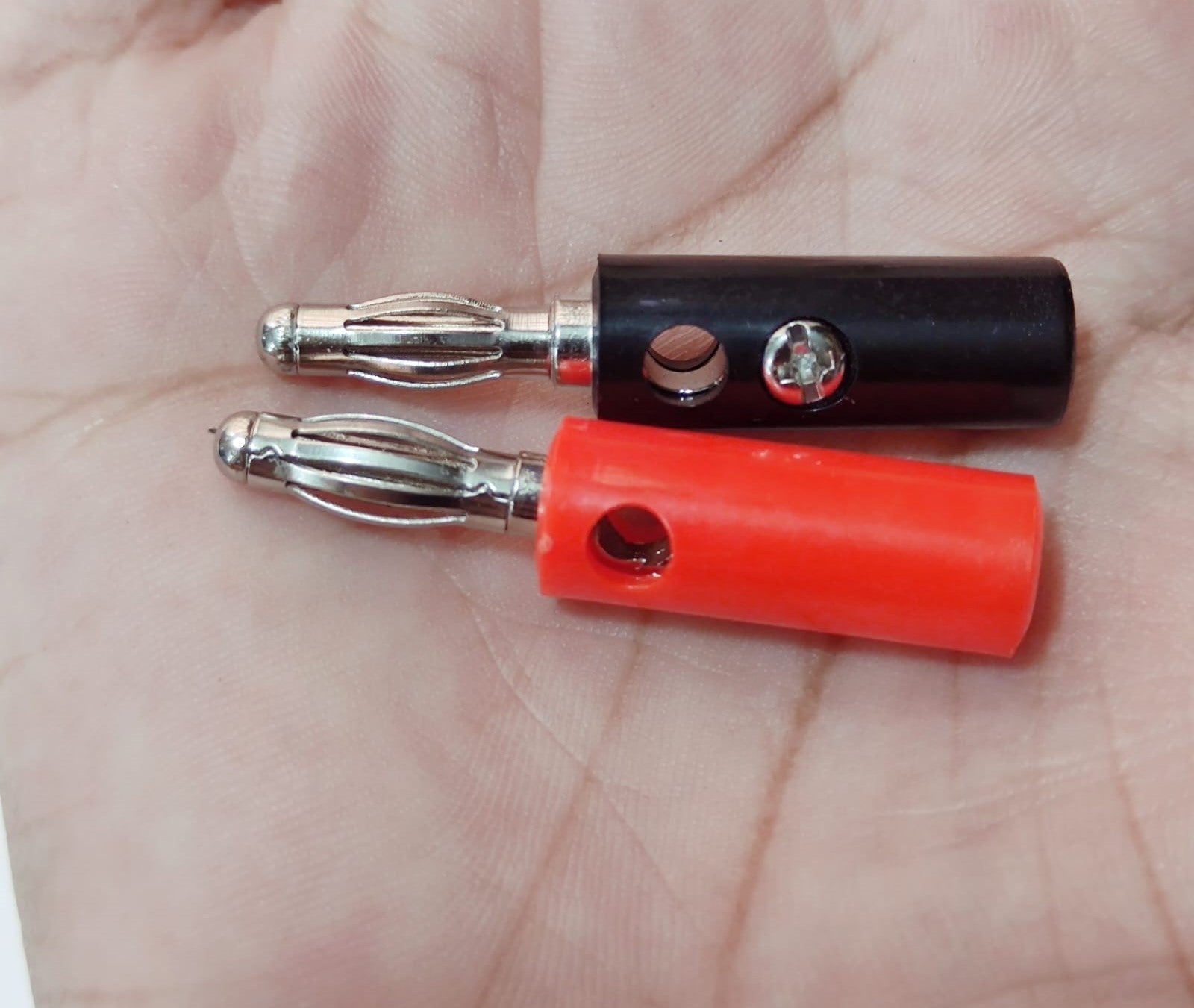 Pair of 4mm Banana Plugs - one black and one red connector with metallic spring-loaded tips and side-entry screw terminals held in a hand.