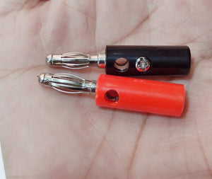 Pair of 4mm Banana Plugs - one black and one red connector with metallic spring-loaded tips and side-entry screw terminals held in a hand.