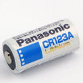 Panasonic CR123A Lithium Battery 3V - a white cylindrical battery with blue and gold branding, shown from a side angle on a plain white background.