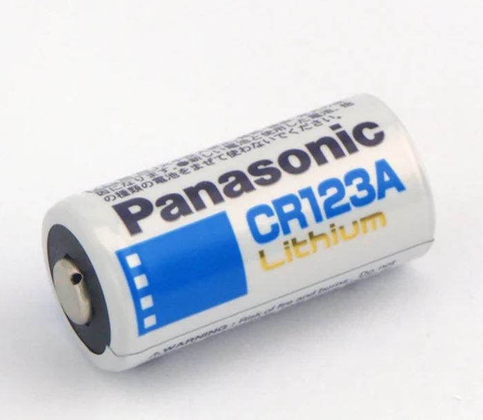 Panasonic CR123A Lithium Battery 3V - a white cylindrical battery with blue and gold branding, shown from a side angle on a plain white background.