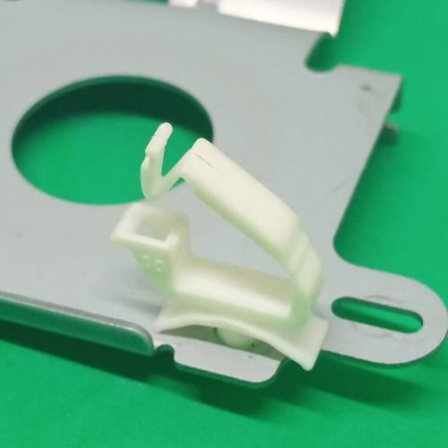 PCB Inserting Hole Cable Clamp, Body PCB Inserting Cable Clamps - a white plastic cable management clip attached to a grey metal plate against a green background.