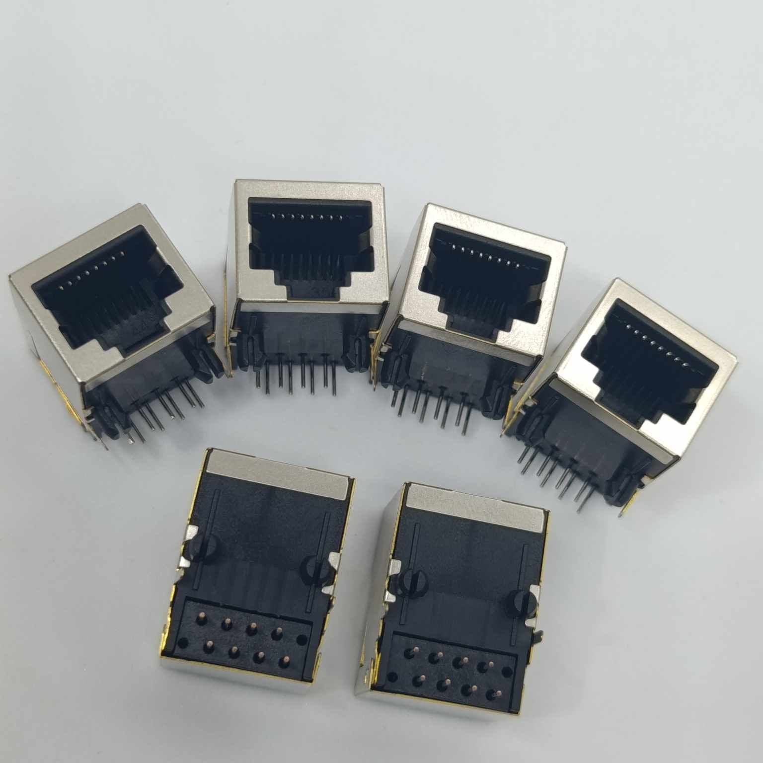 PCB Mount RJ45 Ethernet Connector - six silver and black metal-shielded modular jacks with exposed pins arranged on a white surface.
