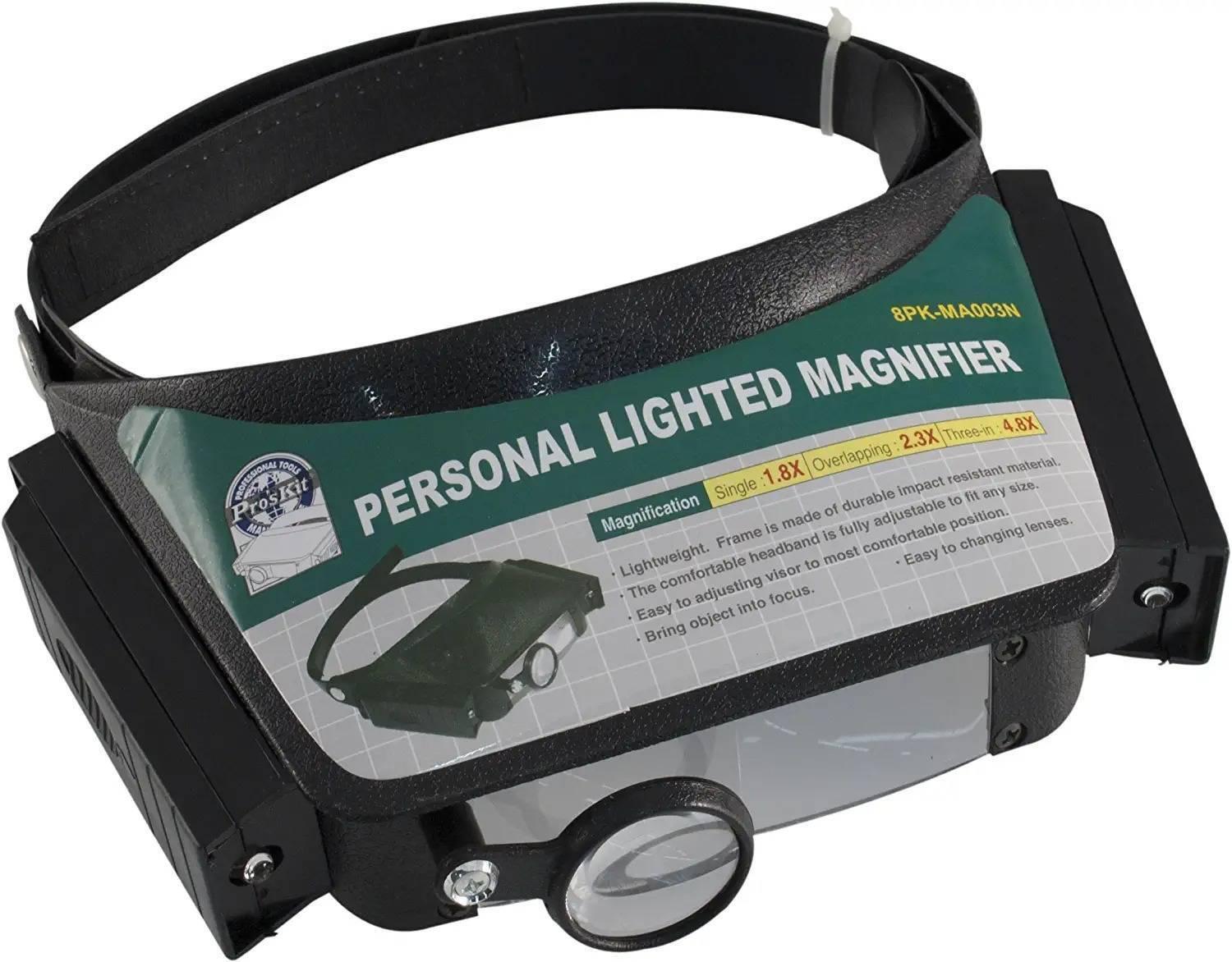 Personal Magnifier Comfortable Headband Light Weight 640mm Proskit 8pk-MA003N - a black headband-mounted magnifying visor with a small circular lens and a green product information label.