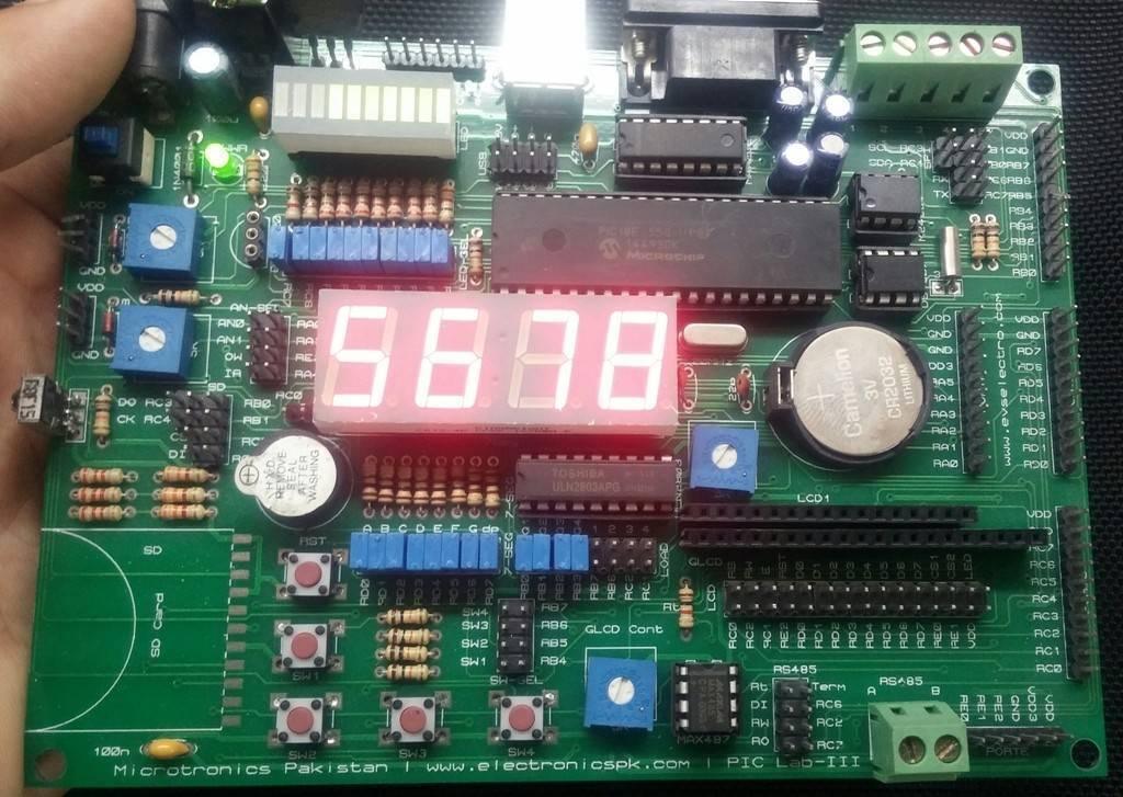 Pic Lab-iii Microchip Pic Microcontroller Development Board - a green circuit board with a red four-digit LED display showing 5678, buttons, and ports.
