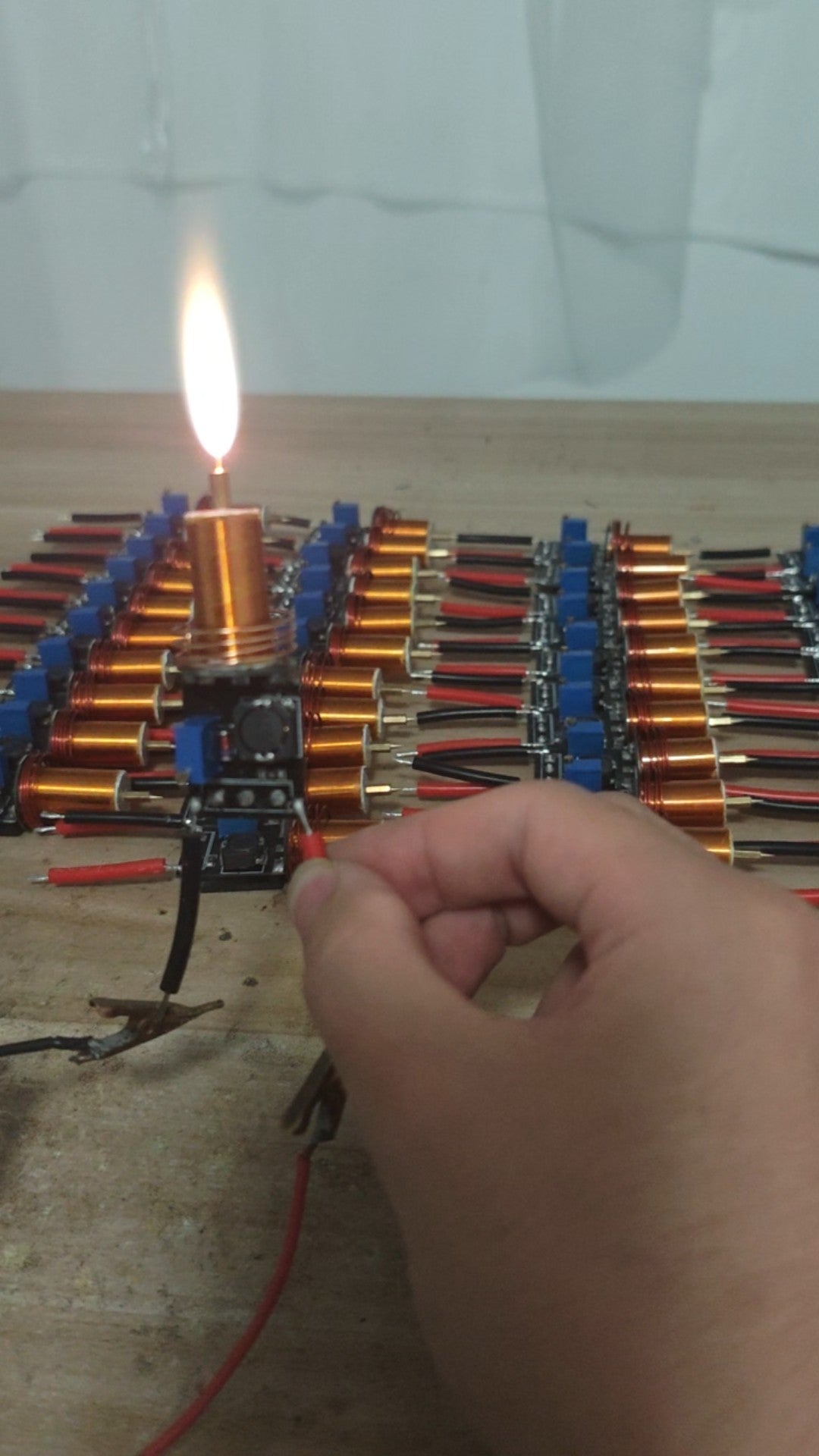 Plasma Arc Fire Head High-Frequency Electric Flame 15–24V Plasma Ignition Module-digilog.pk - a hand holding the black circuit board with a glowing plasma arc.