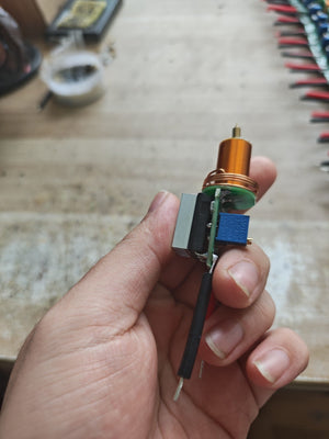 Plasma Arc Fire Head High-Frequency Electric Flame 15–24V Plasma Ignition Module-digilog.pk - a gold-coloured ignition head, a circuit board, and a blue potentiometer.