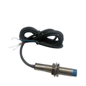 PNP Proximity Sensor - a cylindrical metal threaded body with a blue plastic tip and a black three-wire cable coiled behind it.