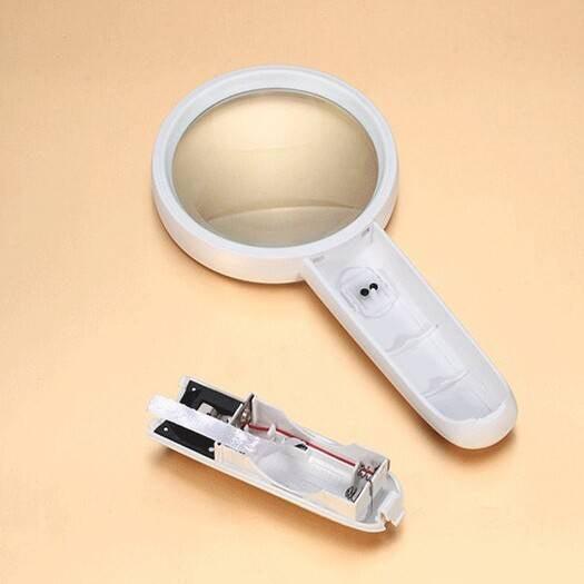 Portable 65mm 4x Handheld Magnifier With High-quality Magnifying Glass LED Lights Mg6b-4 - shown with its white handle casing detached to reveal the internal battery compartment.