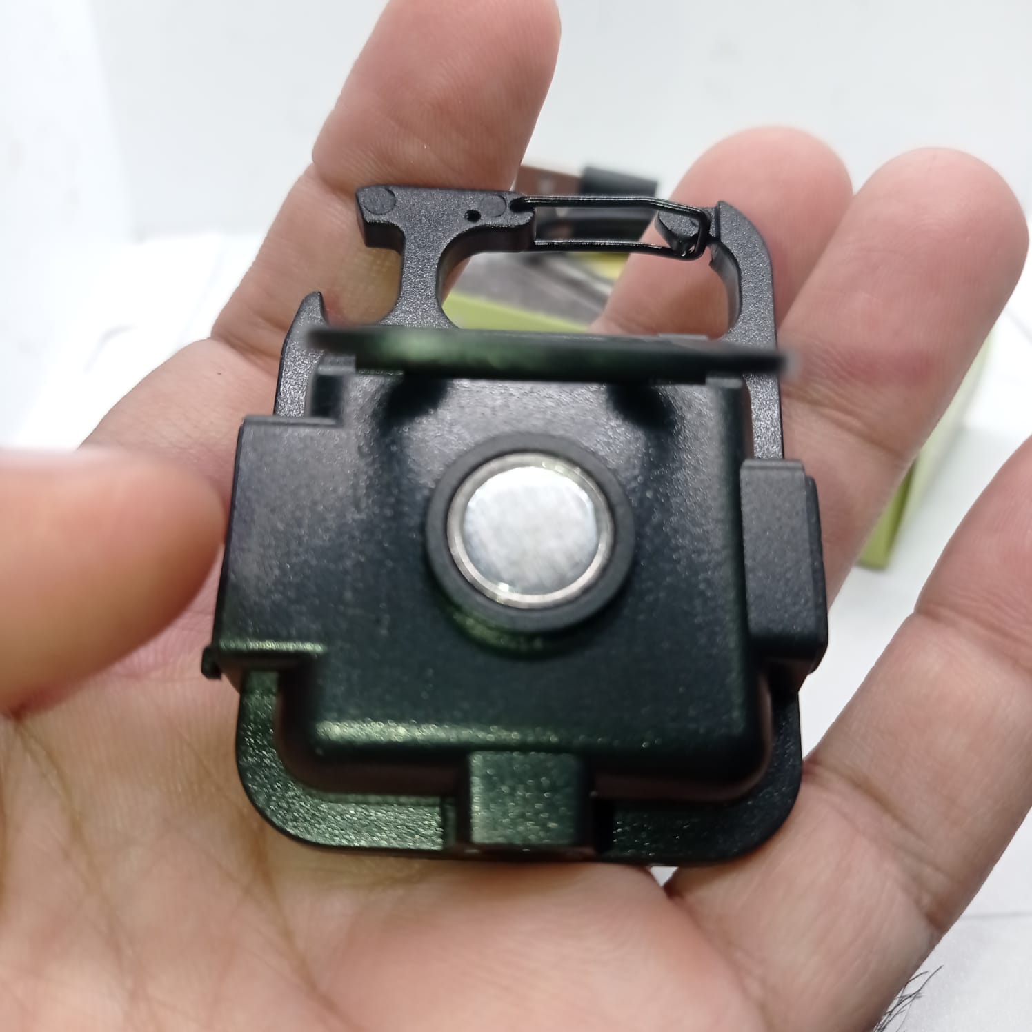 Portable COB Flashlight - Emergency Light with Rechargeable Keychain - Durable Plastic Casing - a black square-shaped keychain light with a central circular magnetic back, held in a hand.