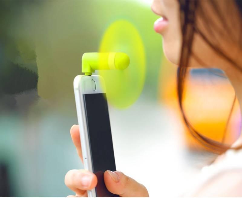 Portable USB Mini Fan For Iphone 5/5s/6/6s/6s Plus - shown in lime green plugged into the top of a white smartphone held by a person.