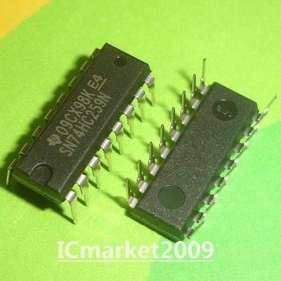 Pre Order 74259 SN74HC259N HD74HC259P 74HC259 DIP-16 - SN74HC259N: Two black 16-pin DIP integrated circuit chips with silver metal legs resting on a green and yellow surface.