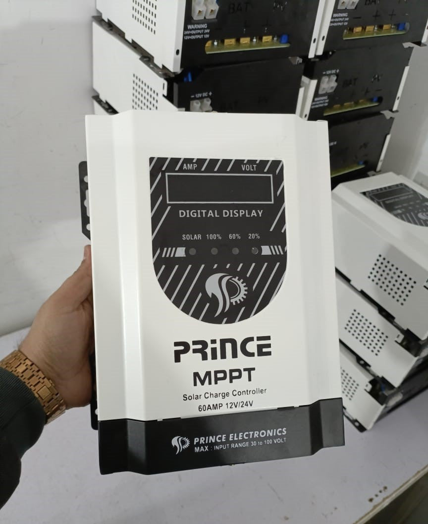 Prince 60A MPPT Solar Charge Controller With Wapda Option - a white rectangular device held in a hand, featuring a digital display and solar status indicator lights.