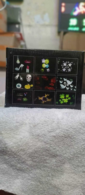 Projector - Projector packaging box showing a grid of nine different light projection patterns, including stars, butterflies, clovers, and birthday themes.