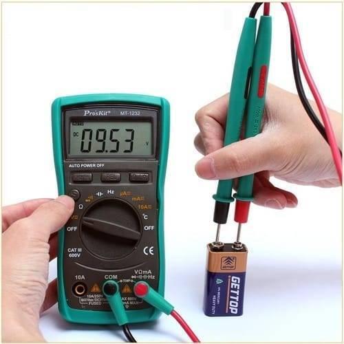 Proskit Autorange Digital Multimeter Mt 1232 For AC DC Voltage Current Resistance Temperature Measurement Tester - with a green casing, rotary dial, and LCD screen showing 09.53 V while testing a 9V battery with probe leads.