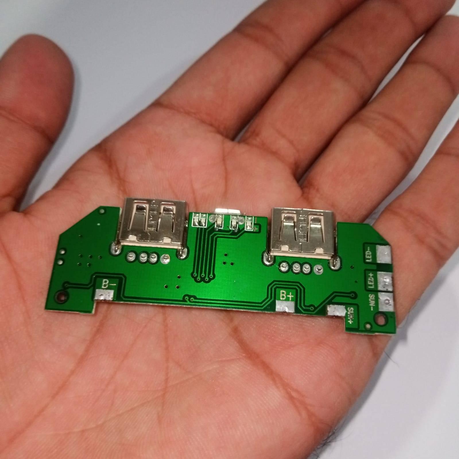 Pull Out 5V 2A DIY Power Bank Module With Emergency Light Points - shown as a green circuit board with two USB ports held in a hand.