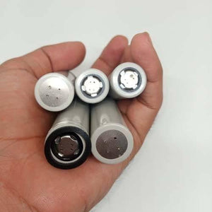 Pull-out High Quality 18650 3.7V 2600mAh Molicel Cell Battery - a hand holding five grey cylindrical batteries with exposed circular contact ends.