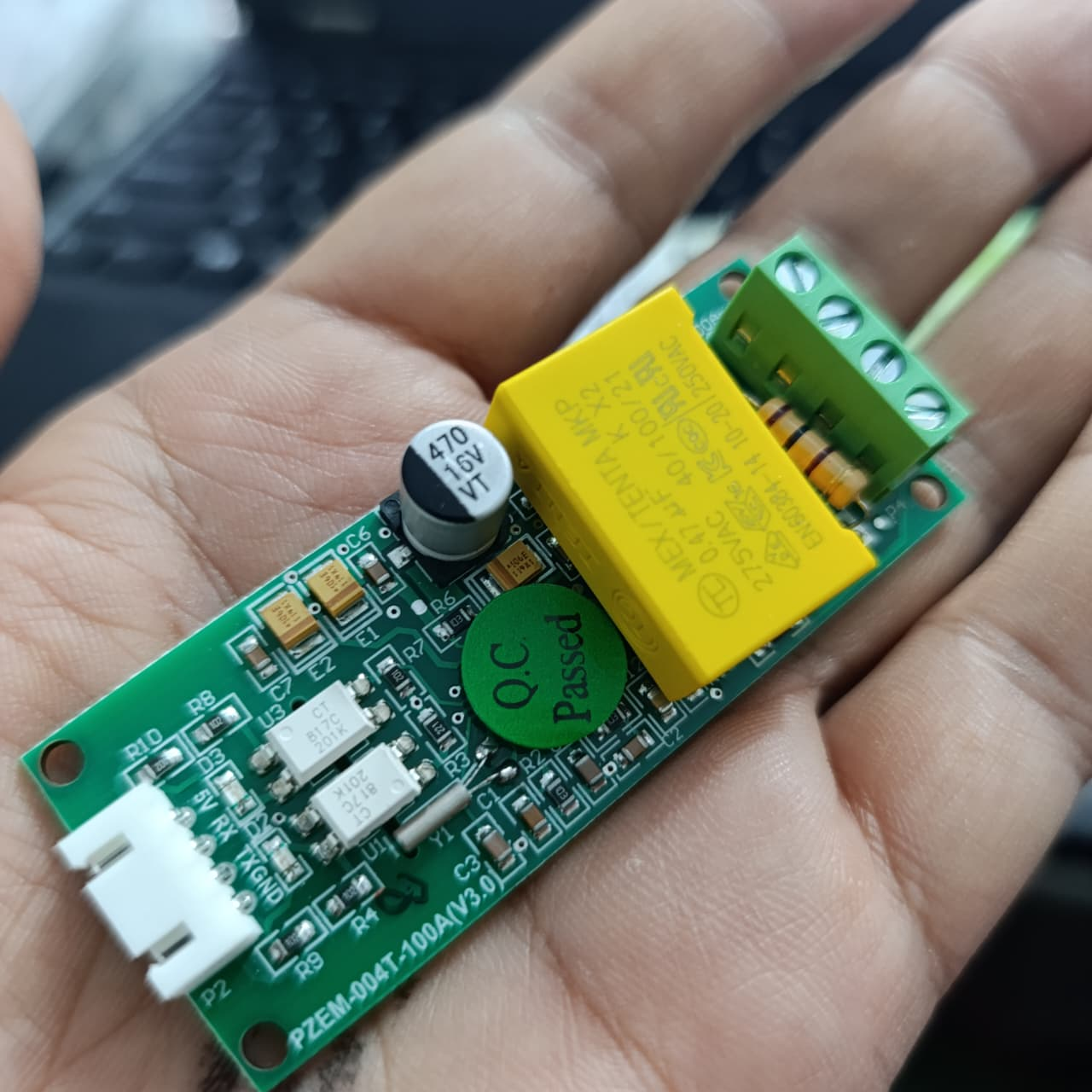 PZEM-004T 100A Single Phase Power Energy Meter Module - a green circuit board with a yellow capacitor, a screw terminal block, and a white connector.