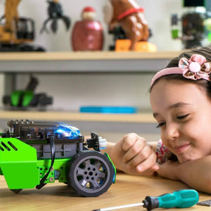 Q-scout STEM Robot For Kids By Robobloq - a green and grey toy robot with a blue light, sits on a table next to a screwdriver and a smiling girl.