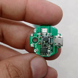 QW2672 Torch Light Emergency Light Controller Module - a circular green PCB with a micro-USB port, a push button, an LED, and solder pads for LED output.