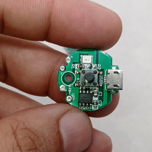 QW2672 Torch Light Emergency Light Controller Module - a circular green PCB with a micro-USB port, a push button, an LED, and solder pads for LED output.