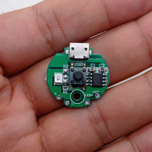 QW2672 Torch Light Emergency Light Controller Module - a circular green PCB held in a hand, featuring a micro-USB port, a push-button, and an LED.
